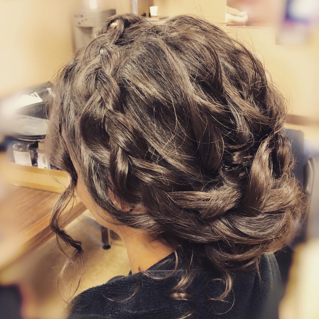 Side back look of a wedding low updo hair. The wave and braid perfectly blend into the knot.